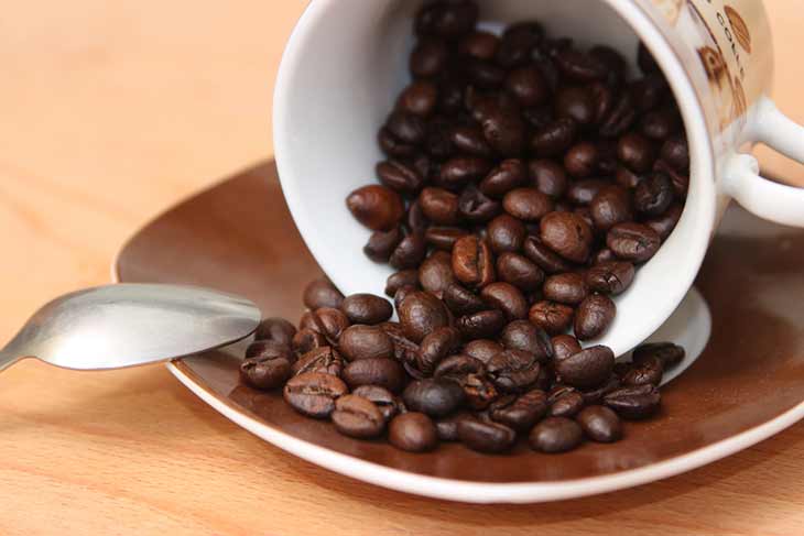 cup of spilt roasted coffee beans